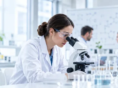 Illustrative laboratory researcher working with a microscope